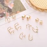 A close-up view of various gold and silver hair braid and dreadlock cuffs, showcasing different unique designs.